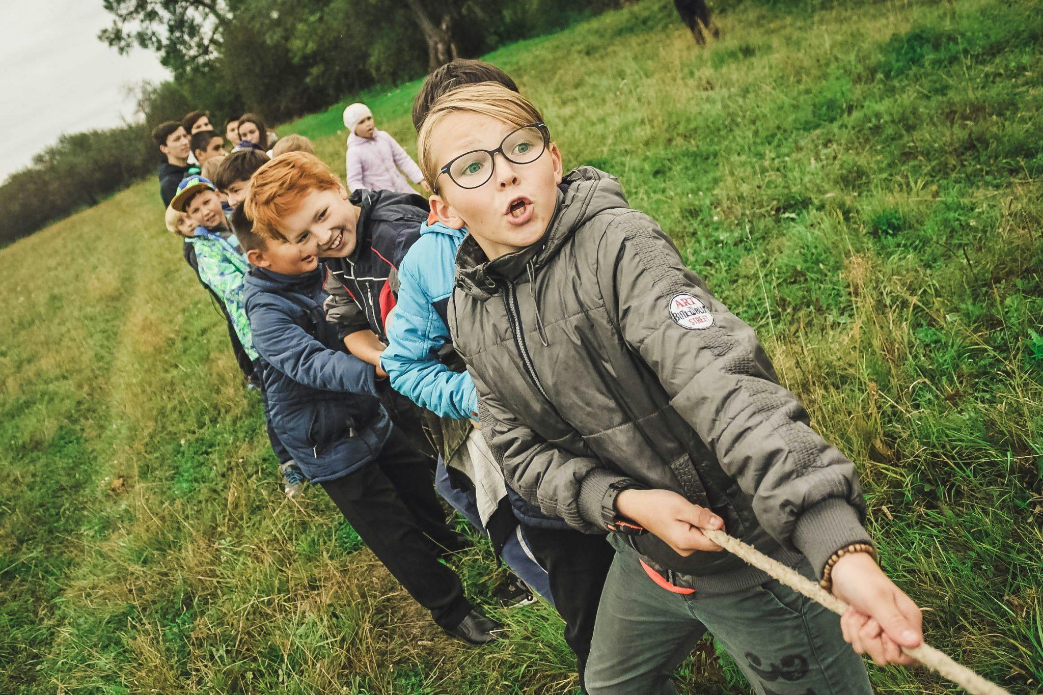 Niños jugando y tirando de una cuerda en el campo